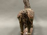 statue of a horse with a saddle on its back on a gray surface
