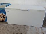 a white refrigerator and a blue trash can in a room
