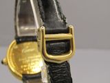 un gros plan d'une montre-bracelet avec une boucle en or
