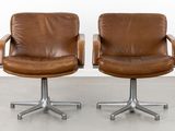 two brown leather swive chairs with chrome steel legs and casteors