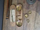 a wooden table topped with brass objects on top of a wooden floor