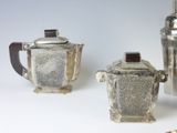 three silver teapots sitting next to each other on a table