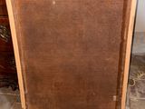 an old picture frame sitting on top of a tile floor next to a dresser