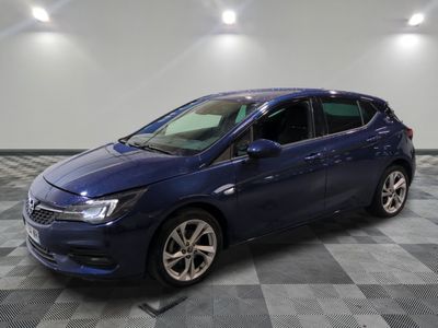 une voiture bleue garée dans un garage au sol en damier