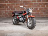 a red motorcycle parked in front of a brick wall