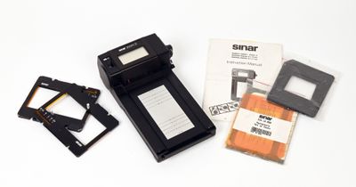 un petit appareil photo et quelques autres objets posés sur une surface blanche