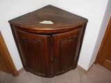a corner cabinet in the corner of a room