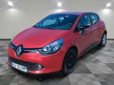 une voiture rouge est garée dans une pièce au sol en damier