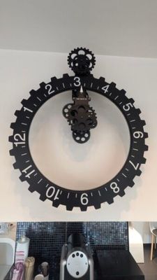 une horloge accrochée au mur au-dessus d'un lavabo dans une salle de bains