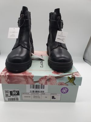 bottines en cuir noir avec des boucles sur le dessus d'un talon carré