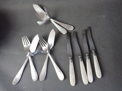 five forks and five knives on a table