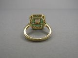 Gros plan sur une bague en or ornée d'une pierre verte