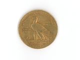 a gold coin with a bird on it on a white surface