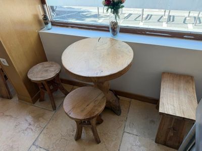 a small table and two stools in front of a window