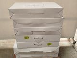 Plusieurs cartons de pizza sont empilés sur une palette dans un entrepôt