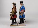 pair of figurines of two men dressed in historical clothing