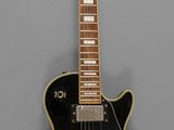 an image of a black electric guitar on a gray background