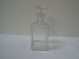 a clear glass bottle with a flower design on it