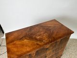 an old wooden chest sitting on top of a carpeted floor next to a lamp
