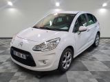 la voiture blanche est garée sur un sol en damier dans le garage