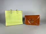 two leather bags with handles and handles sitting side by side on a gray surface