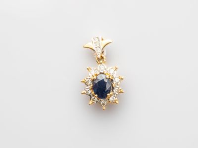 a sapphire and diamond pendant on a white background