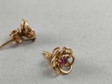 a close up of a pair of gold earrings with pink stones