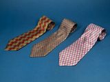 three ties are lined up on a blue surface