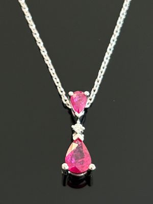 un gros plan d'un collier orné de pierres roses sur un fond noir