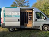 a van that is parked in the grass with its doors open