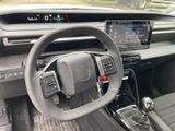 the interior of a car with a steering wheel and dashboard controls