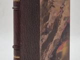 un vieux livre à la couverture marron posé sur une table blanche