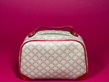 a white and red cosmetic bag sitting on a pink surface