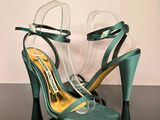 pair of green high heeled shoes on a black table