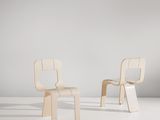 une paire de chaises en bois posées sur un sol blanc