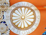 a close up of an orange table cloth with a blue bird on it