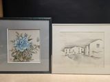 two framed drawings of a house and a flower on a table