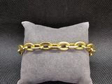gros plan d'un bracelet en chaîne en or sur un oreiller