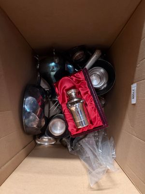 a cardboard box filled with many different types of pots and pans
