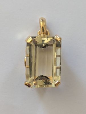un pendentif en or jaune orné d'une émeraude au centre