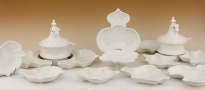 beaucoup d'assiettes et de bols blancs sur la table
