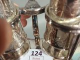 someone is holding a silver salt and pepper shaker in their hand