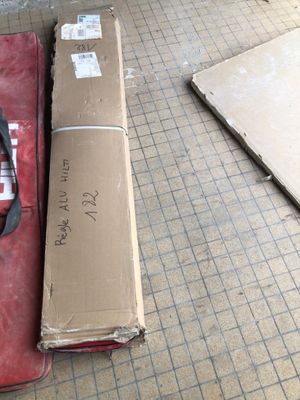 une valise rouge posée par terre à côté d'un carton
