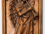 an image of a wooden plaque with an angel holding a trumpet