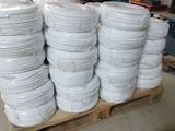 several stacks of white plates stacked on a pallet in a warehouse