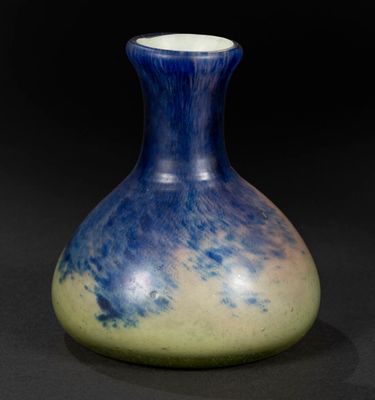 a blue and yellow vase sitting on a black surface