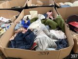 a cardboard box full of clothes and toys on the ground