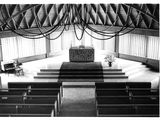black and white photo of a church with pews and a cross