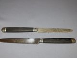 two knives that are sitting next to each other on a table