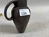 un petit vase noir sur lequel est accrochée une étiquette de prix